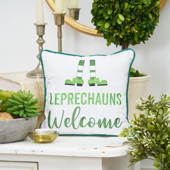 leprechauns welcome mini pillow on a table with plants