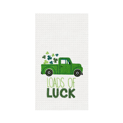 white waffle weave towel with a green truck with clovers in the tailgate with the words "loads of lucks" written on a dark and light green