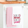 embroidered flour sack towel with the phrase love is patient love is kind surrounded by flowers hanging from a kitchen counter