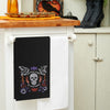 black waffle weave towel with a skull and the phrase you have magic in your bones surrounded by mystical elements hanging from a kitchen counter