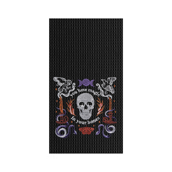 black waffle weave towel with a skull and the phrase you have magic in your bones surrounded by mystical elements