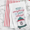 embroidered flour sack towel with the phrase Merry Everything and Happy Always above a polar bear wearing winter gear on a marble countertop