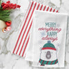 embroidered flour sack towel with the phrase Merry Everything and Happy Always above a polar bear wearing winter gear on a marble countertop