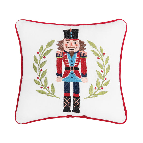 nutcracker wreath mini pillow with a nutcracker over a wreath on a white pillow with red trim