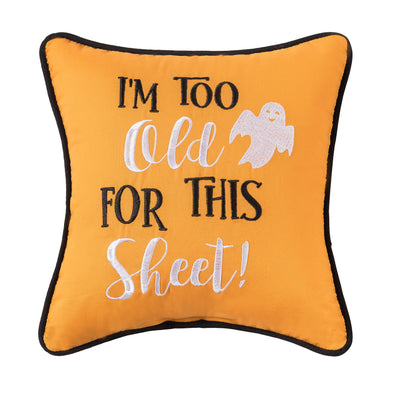 orange embroidered mini pillow with the cheeky phrase of I'm Too Old for this Sheet next to a smiling ghost