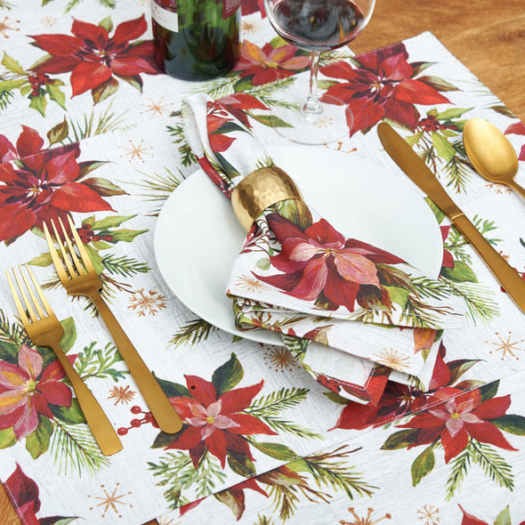 painterly poinsettias and foliage on printed table linens on a wood table