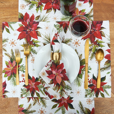 painterly poinsettias and foliage on printed table linens on a wood table