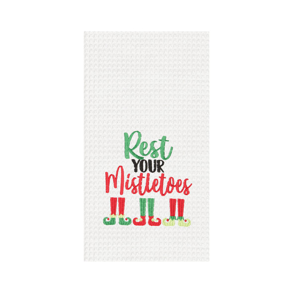Rest your mistletoes waffle weave kitchen towel, elf legs and feet peeking under the words "rest your mistletoes" in red and green