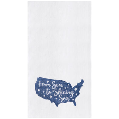 flour sack towel with an outlined shape of america in blue with the words from sea to shining sea in white over top surrounded by delicate white stars