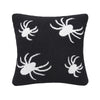 knitted pillow with white spiders on a black background