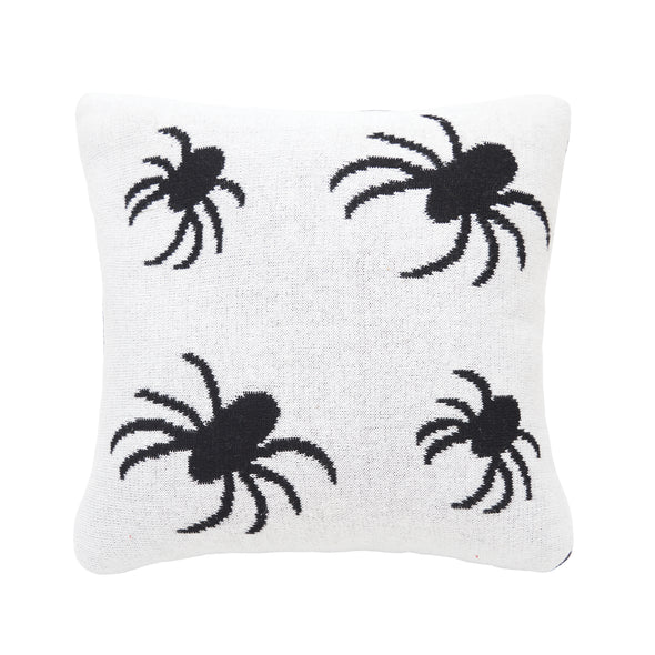 knitted pillow with black spiders on a white background