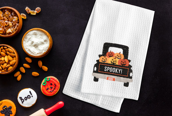 Spooky Pumpkin Truck kitchen towel styled in a Halloween themed flat lay.