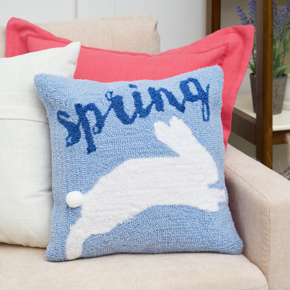 spring bunny pillow on a couch with a teal and pink pillow