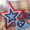 a hooked pillow shaped like a star with a red border and white dark blue and light blue stars that form smaller stars paired with additional patriotic decor and pillows