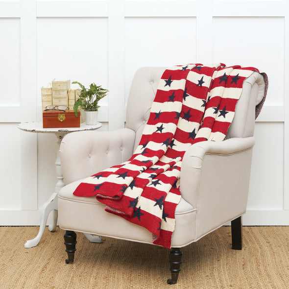 knitted throw with red and white stripes and navy blue stars on a chair