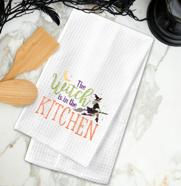 The Witch is in the Kitchen, kitchen towel styled on a marble countertop.