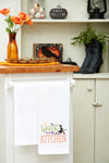 The Witch is in the Kitchen, kitchen towel styled in a Halloween themed kitchen.