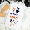 flour sack towel with embroidered Halloween icons including a witch, black cat, and bats on a marble counter