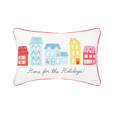 village holiday pillow with red, blue and yellow houses lined up and decorated with lights as well as "home for the holidays!" at the bottom