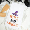 flour sack towel with embroidered phrase of witch and famous topped with a witches' hat and stars on a marble countertop