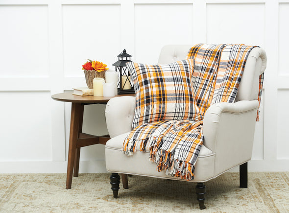 woven orange black and white throw with a matching pillow on a chair