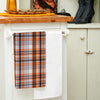 woven orange black and white plaid kitchen towel hanging from a kitchen countertop