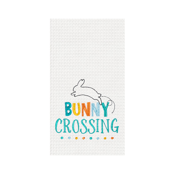 bunny crossing sentiment and hopping bunny icon embroidered on a white waffle weave kitchen towel